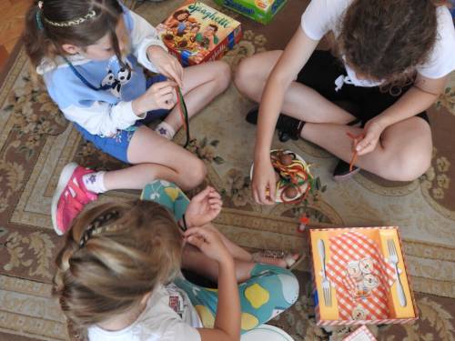 Dzieci na dywanie grają w gry planszowe